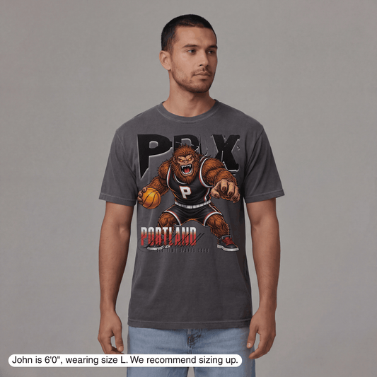 Man wearing a gray t-shirt with a graphic design on a plain background