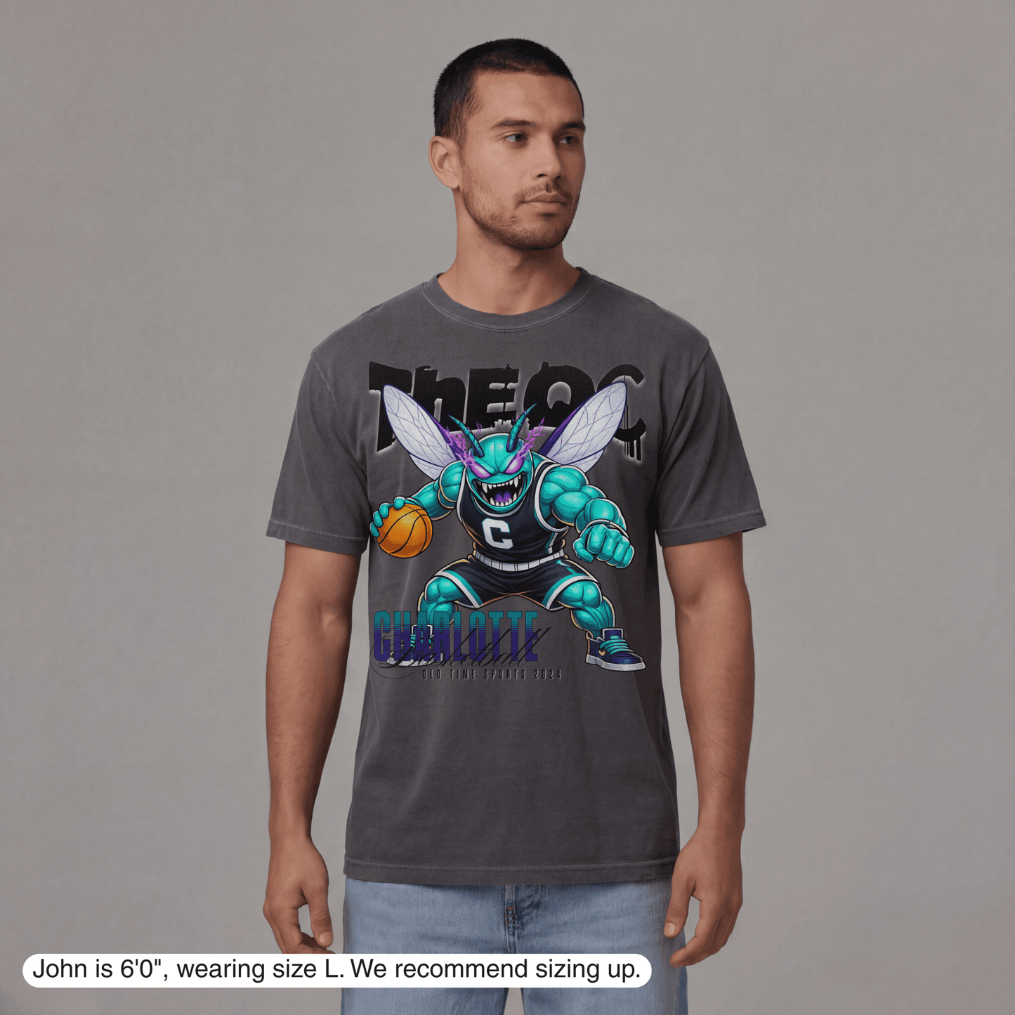 Man wearing a gray t-shirt with a graphic design on a plain background