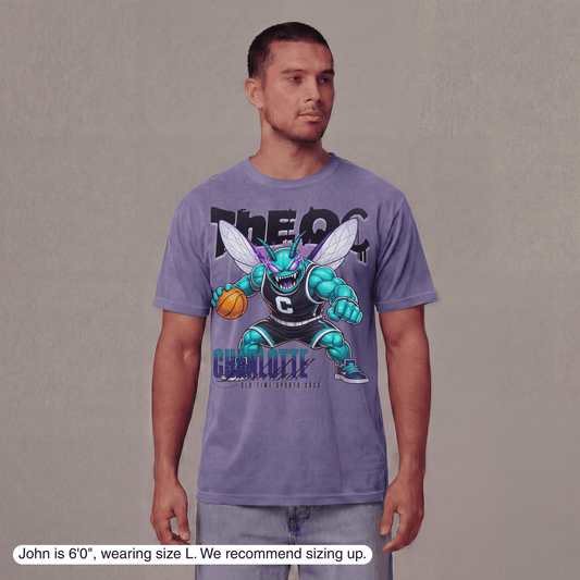 Man wearing a purple t-shirt with a graphic design on a plain background