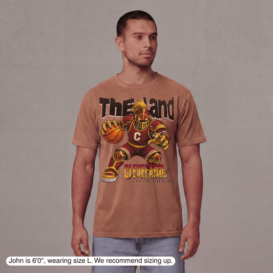 Man wearing a brown t-shirt with a graphic design on a plain background