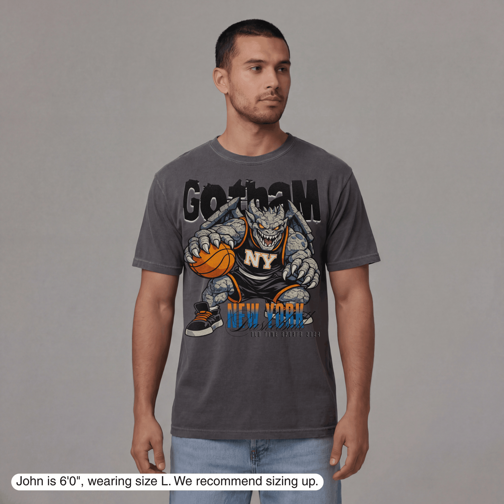 Man wearing a gray t-shirt with a graphic design on a plain background