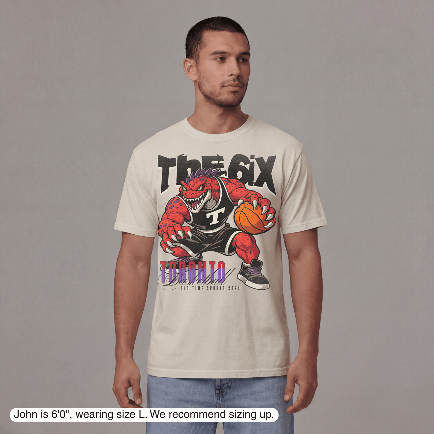 Man wearing a t-shirt with a graphic design of a red dinosaur holding a basketball and text.