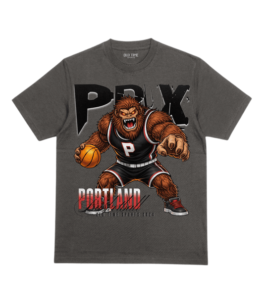 Gray t-shirt with a bear-like character holding a basketball and the word 'PDX' on a transparent background